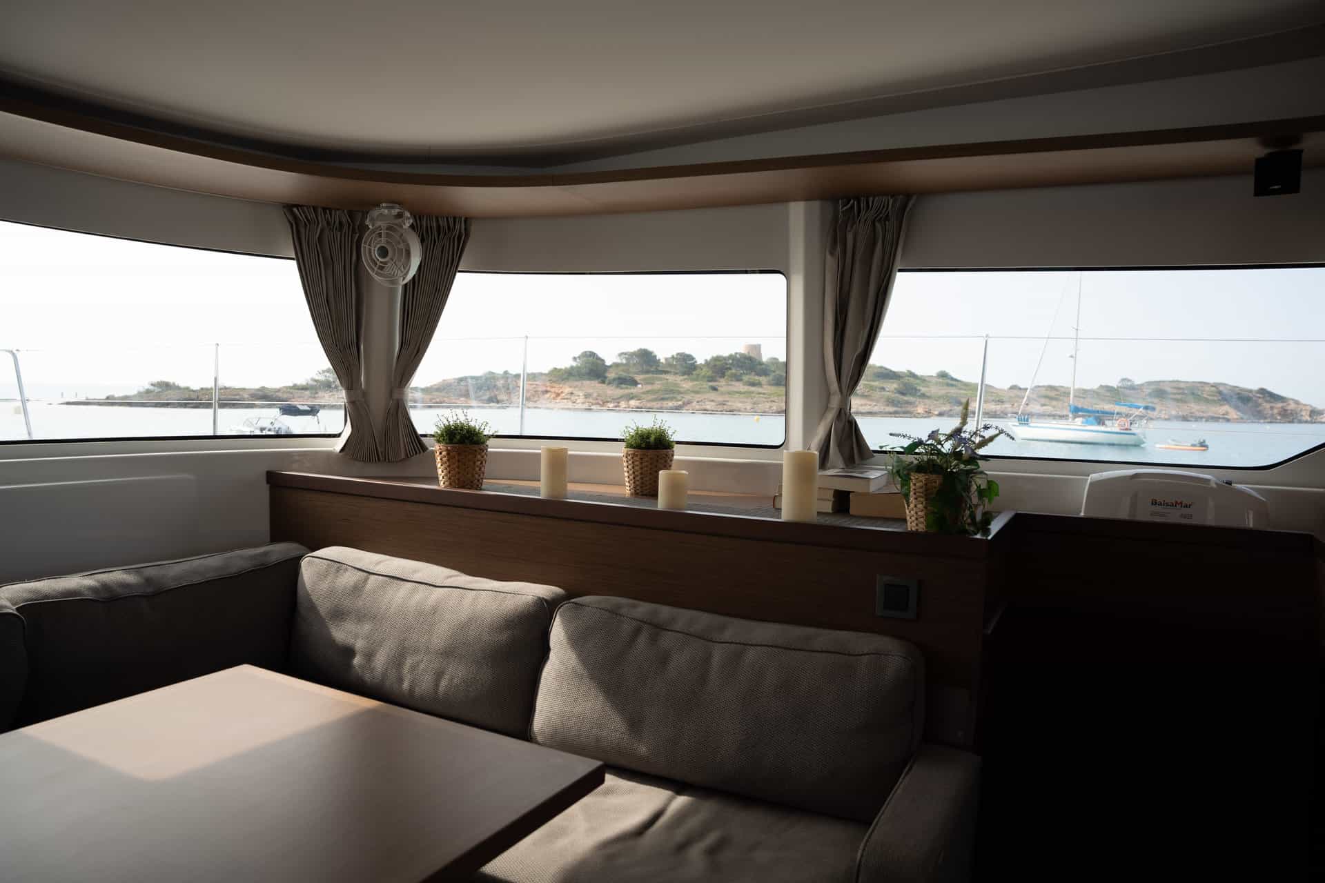 Salón interior del catamaran de lujo de ECC Yacht Charter fondeado en una cala de Mallorca