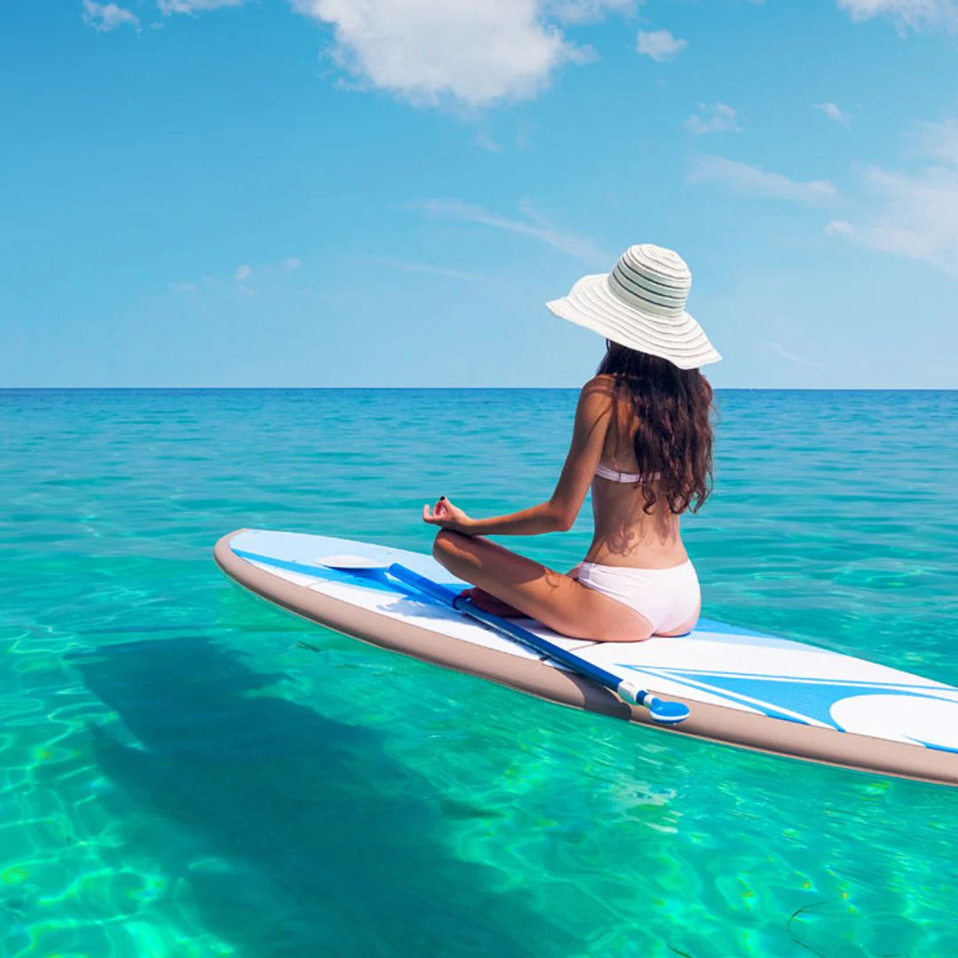 En esta foto encontramos a una mujer disfrutando en un paddle surf en las cristalinas aguas de Mallorca.